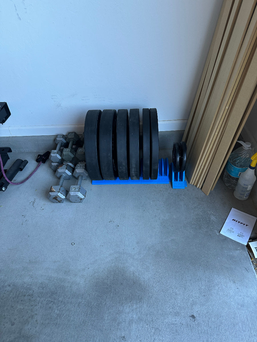 Set of dumbbells on a concrete floor next to a white wall