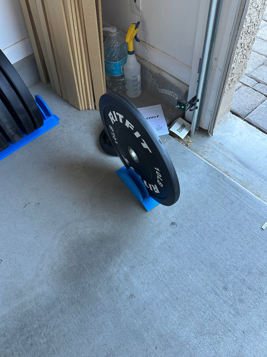 Weight plate with a blue holder on a concrete floor