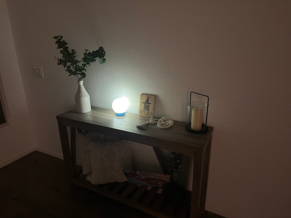 Moon lamp glowing on a console table in a dark room