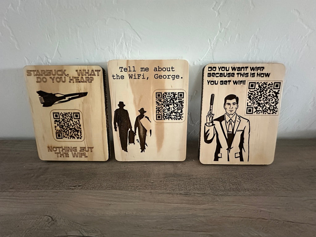Three rectangular wooden sign plaques with laser-engraved Star Trek-themed quotes and QR codes, displayed on a wooden surface against a textured white wall.
