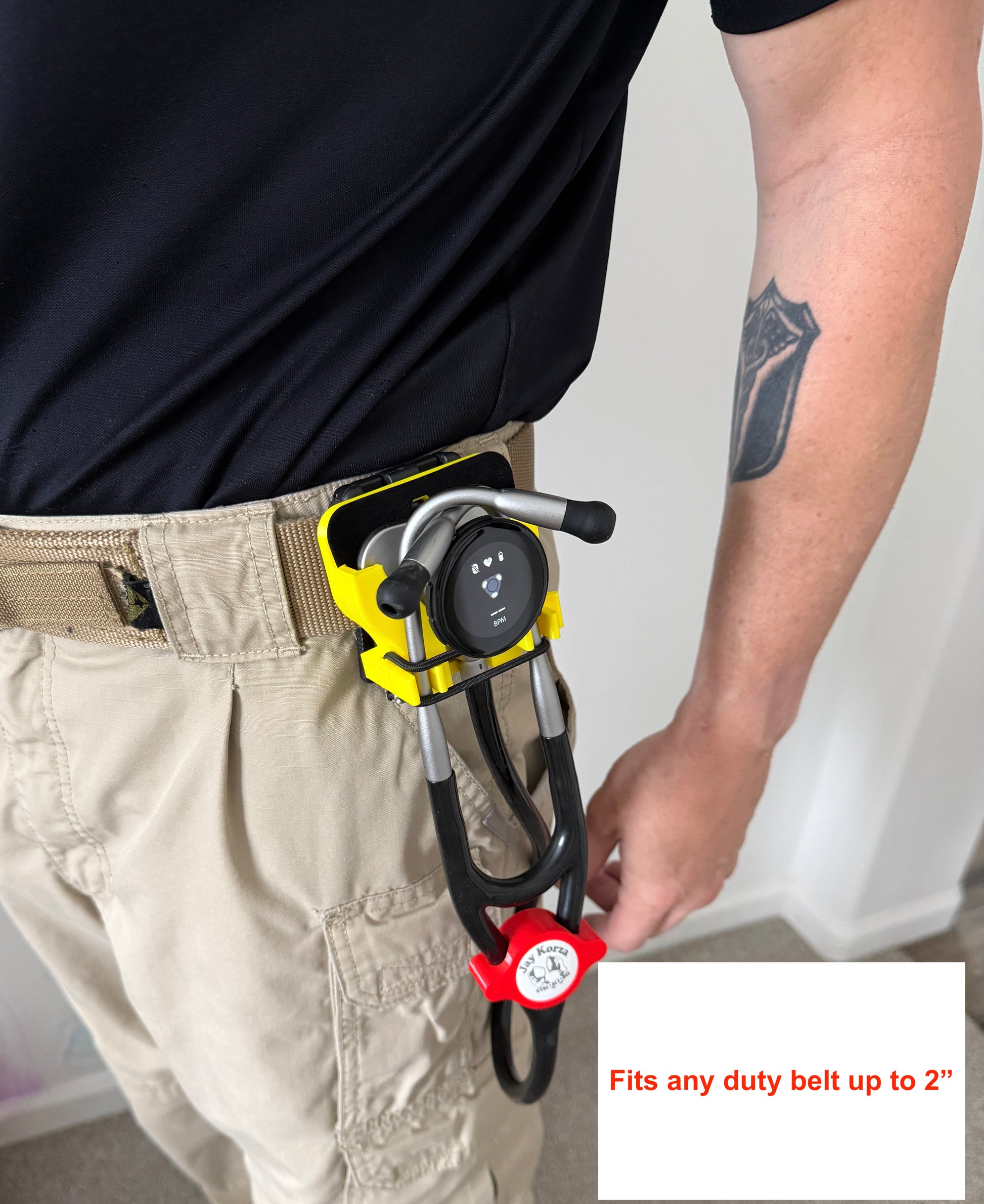 Person wearing a belt with a carabiner and lanyard holder attached, on a plain background.