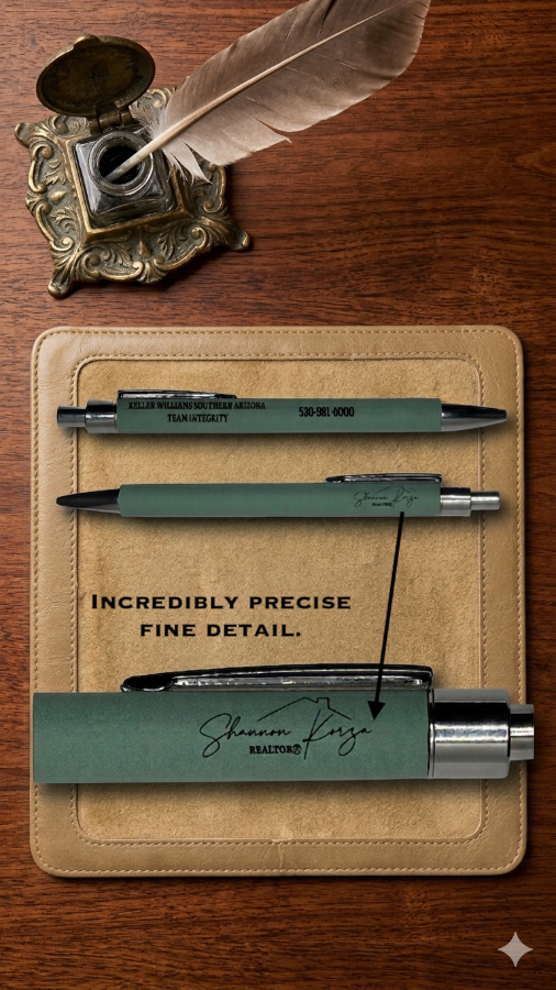 Three pens on a leather case with an inkwell and feather on a wooden surface