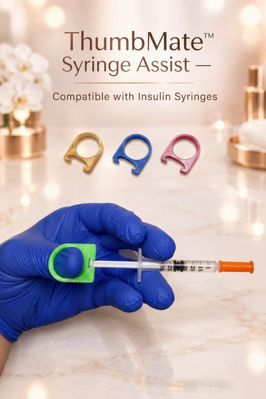 A gloved hand holds a syringe fitted with a green ThumbMate Assist ring. The image includes the text 'ThumbMate Syringe Assist — Compatible with Insulin Syringes' and shows three small ring colors above the hand.