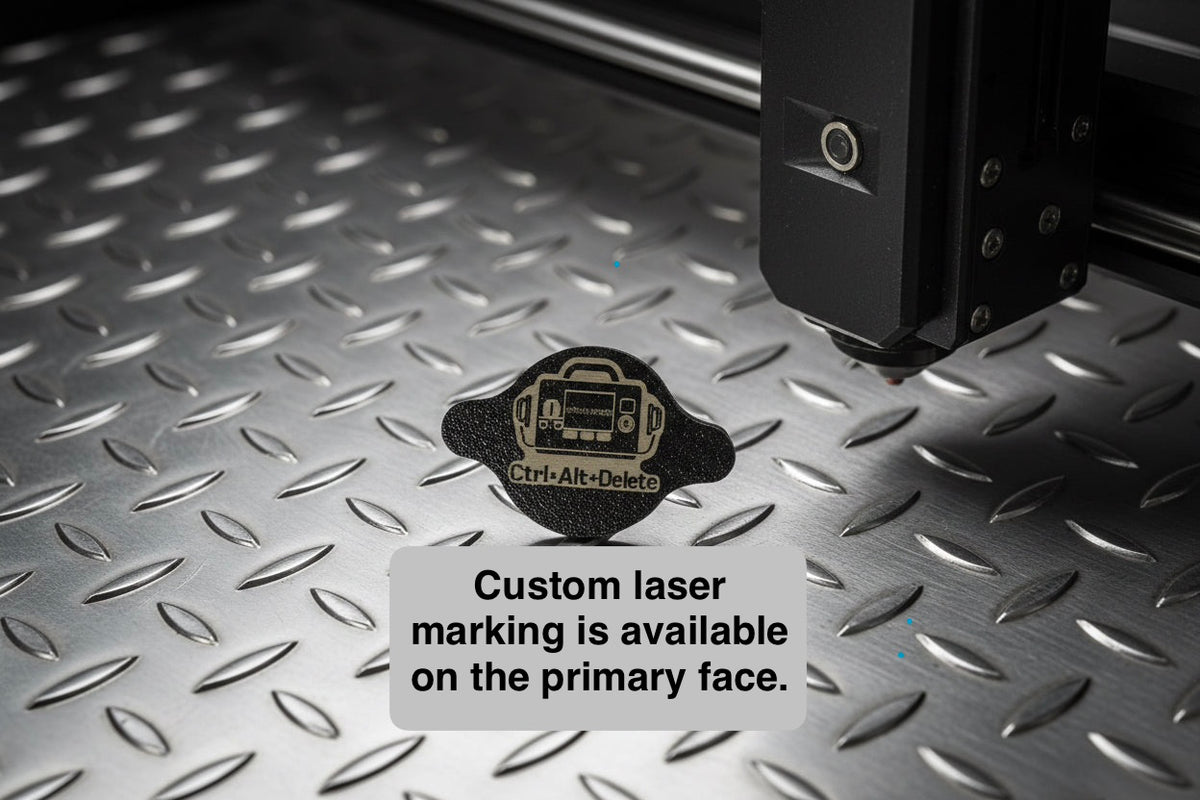 Black AirTag holder with a custom laser-marked design on the front, on a laser bed
