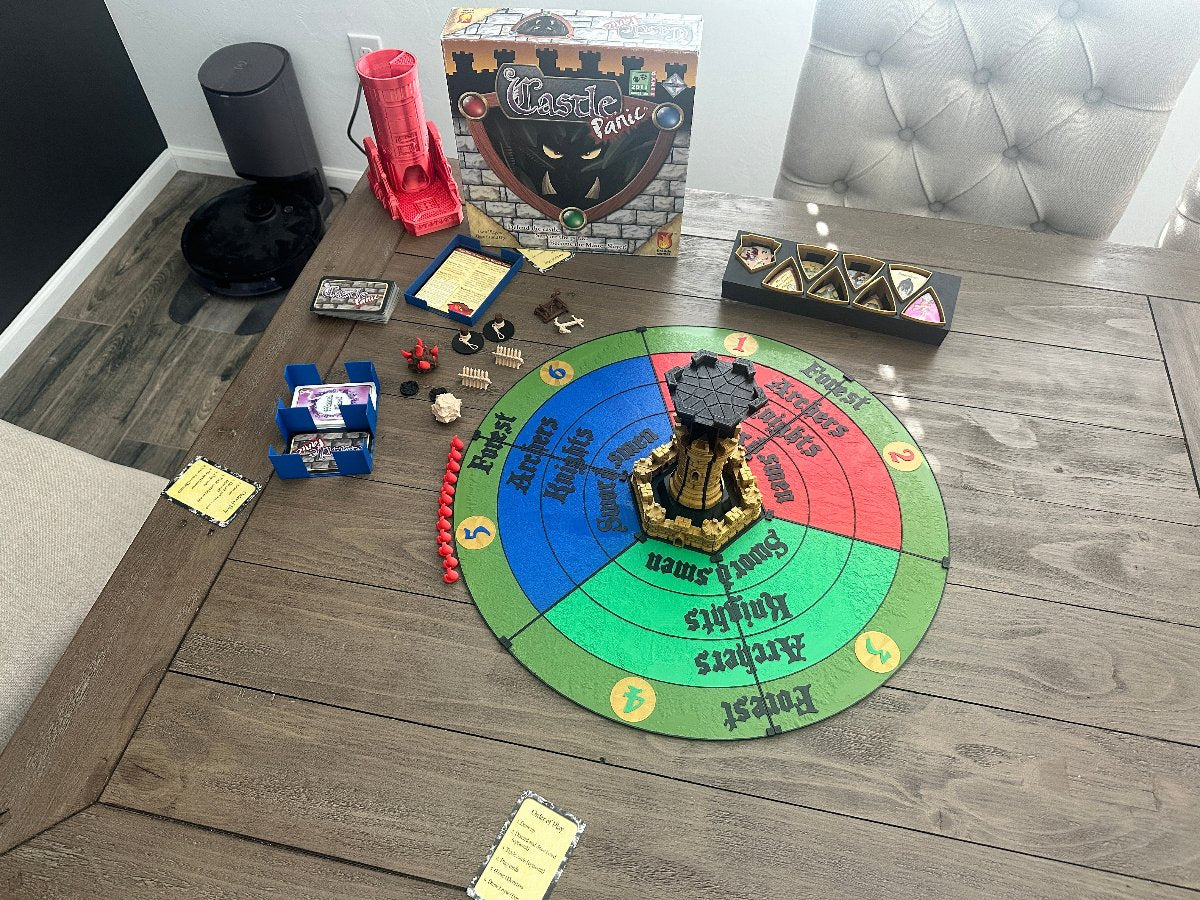 Castle Panic game with 3D printed pieces and round board on a dining table
