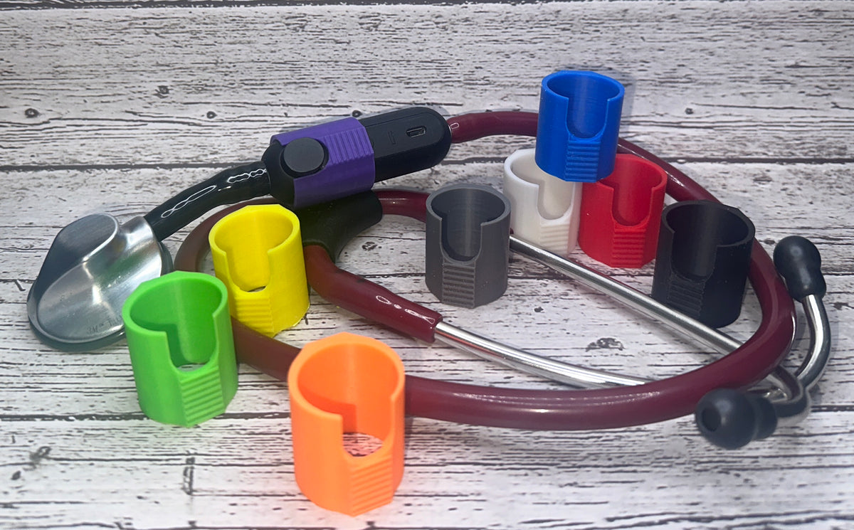 Power blockers in black, purple, blue, white, gray, red, yellow, green and orange around a Littmann Eko CORE stethoscope on wood