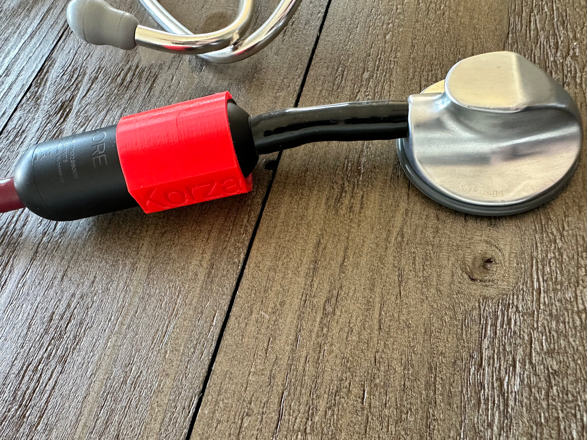 Red power blocker installed on a Littmann Eko CORE next to the chestpiece on a wood table