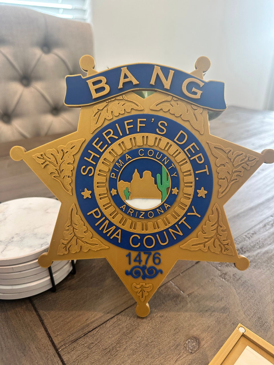 Close-up of the gold and blue sheriff star lid on the BANG! card box