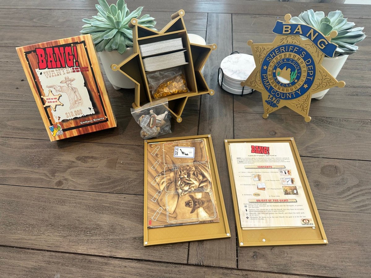 BANG! card game laid out on a table with the gold sheriff star card box