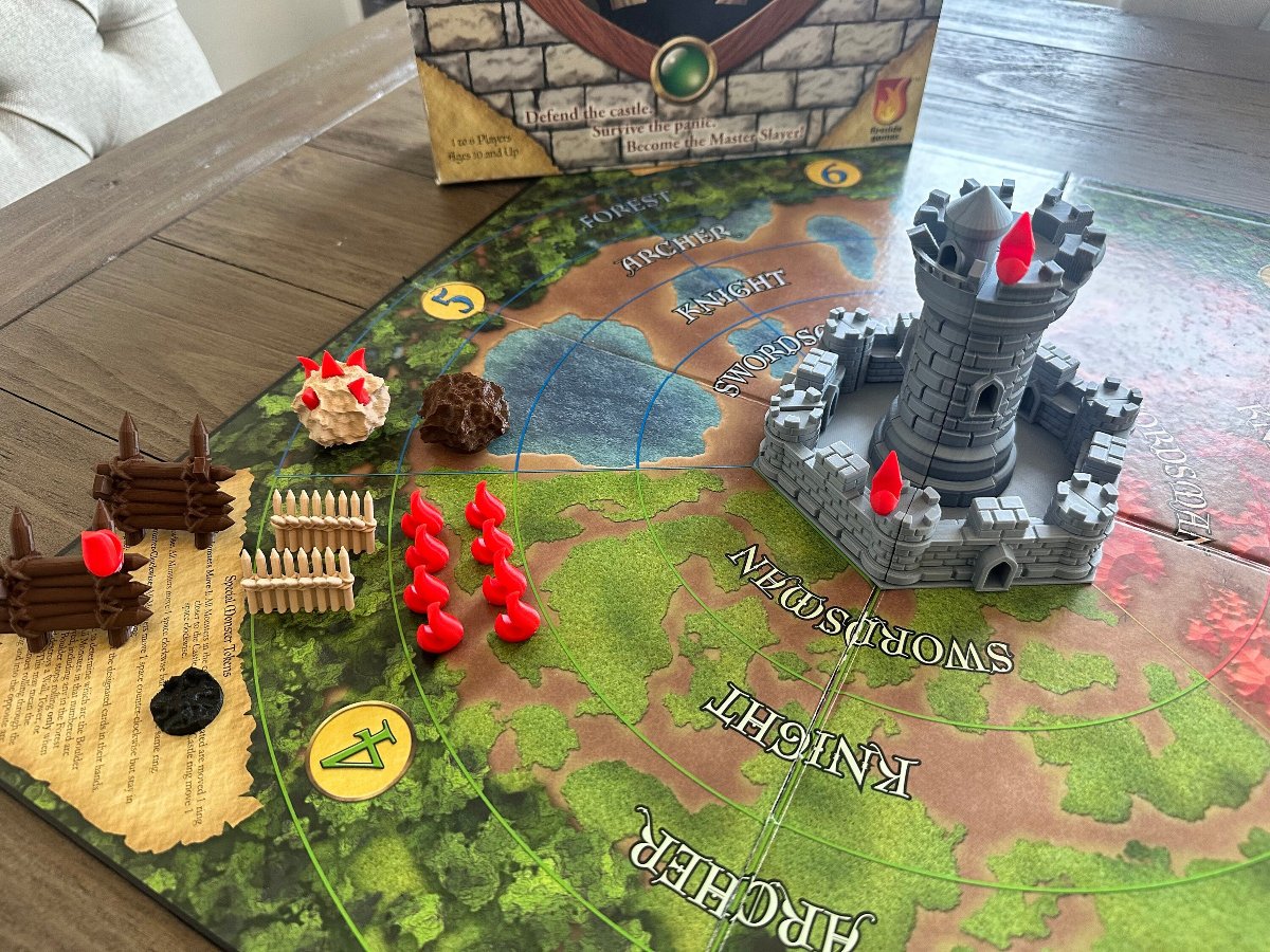 Castle Panic game in play with 3D printed towers, red flames and monster tokens on the board