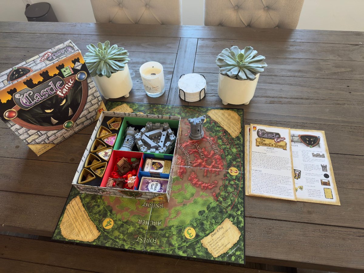 Castle Panic replacement board on a table beside the open game organizer and cards
